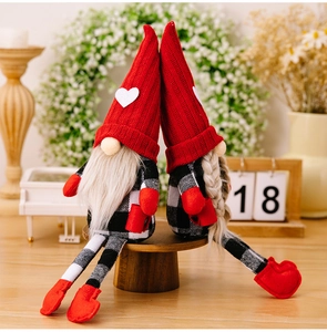 Detail of red knit hats and checkered bodies on pair of Christmas heart gnomes