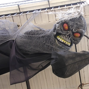 Hanging Halloween ghost decoration with glowing eyes and black tattered gauze robe