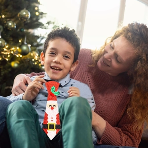 Dettaglio di una cravatta natalizia glitterata rossa con Babbo Natale per feste bimbi