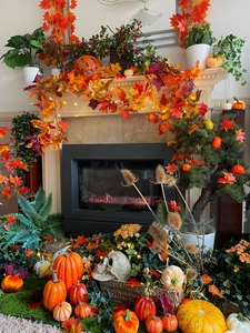 Detail of autumn fireplace mantel with maple leaves, pumpkins, and skull decor