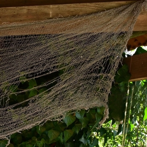Creepy grey cloth hung on wooden beams with torn details for Halloween outdoor decor