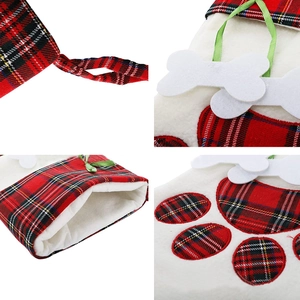 Detail of red and black plaid Christmas dog stocking with white plush cuff and bone charm