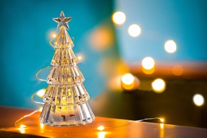 Macro view of crystal Christmas tree ornament with warm LED lights and star topper