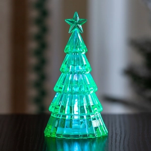 Macro shot of luminous green acrylic Christmas tree with star topper and LED lights