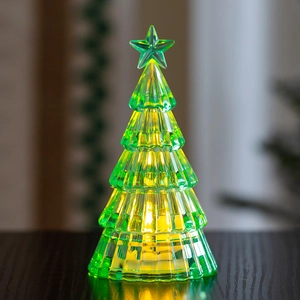 Macro detail of glowing green crystal Christmas tree with warm LED lights and faceted resin