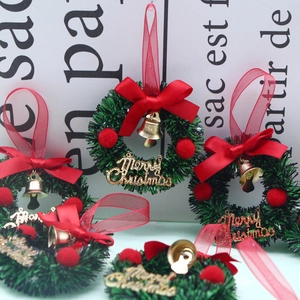 Close-up of five 6cm mini Christmas wreaths with red bows, bells and Merry Christmas signs