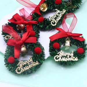 Mini Christmas wreath with red bow and gold Merry Christmas letters for festive decor