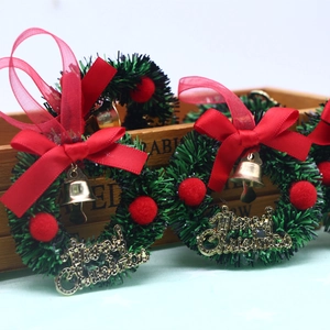 Mini 6cm Christmas wreath with red bow, gold bells and Merry Christmas sign on wood background