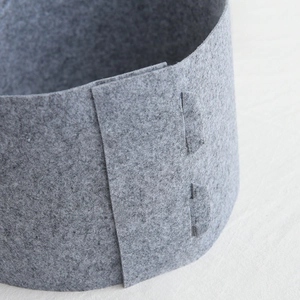 Grey felt Christmas tree skirt showing thick fiber texture and reinforced stitching detail