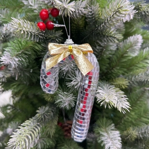 Disco mirror candy cane ornament with gold bow on a green Christmas tree branch