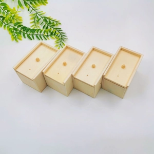Detail of four light wood boxes with sliding lids and ball handles on white background