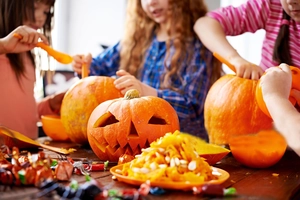 Detail of Jack-o'-lantern carving with seeds and candy during Halloween DIY activity