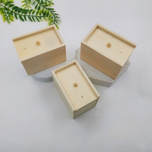 Three minimalist wooden prank boxes with sliding lids and natural grain texture