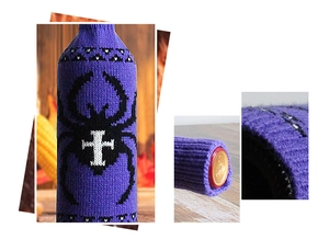 Detail of purple knitted Halloween wine bottle cover with black spider pattern on wood desk