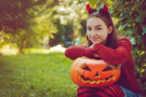 Détail du serre-tête cornes de diable rouges avec plumes noires pour fête d'Halloween