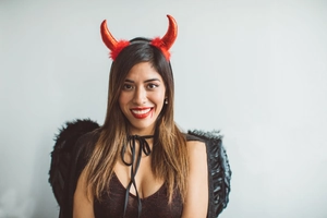 Détail du serre-tête cornes de diable rouges et ailes en plumes noires d'Halloween