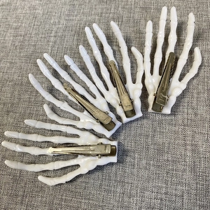 Detail of 4-piece set white skeleton hand hair clips with durable metal alligator grips