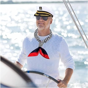 Detail of white captain hat with gold embroidery and nautical striped silk scarf