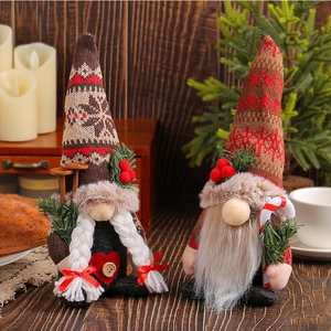 Close-up of handmade Christmas gnomes with knitted snowflake hats and white beards