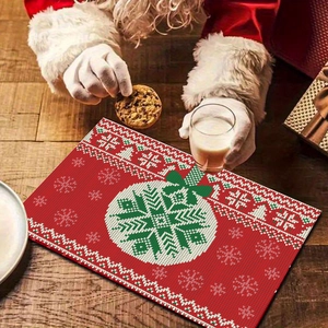 Detail of red Christmas placemat with white snowflake patterns and knitted texture on wood table