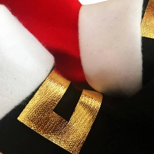 Macro detail of Christmas chair leg cover with red plush fabric and golden belt buckle