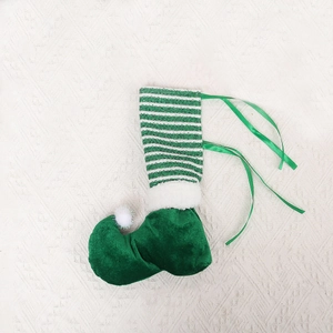 Detail of Christmas elf shoe chair leg cover in green velvet with striped patterns