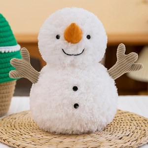 Cute white snowman plush toy with carrot nose and corduroy arms on woven mat