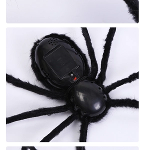 Detail view of the battery compartment and power switch on the 125cm black plush spider