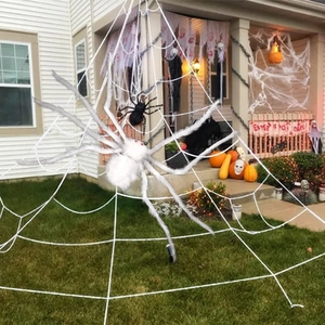 Giant white plush spider with red eyes and large web for Halloween yard decoration