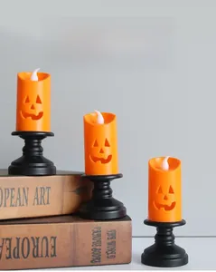 Detailed close-up of three Halloween pumpkin LED candle lights with vintage black stands