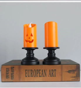 Close-up of LED pumpkin candle lights with black vintage bases on a decorative book