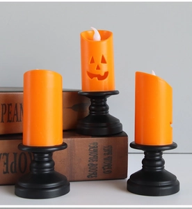 Three pumpkin LED candles with Jack-o'-lantern faces on black vintage stands