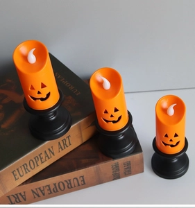 Close-up of three orange LED pumpkin candles with black bases on vintage books
