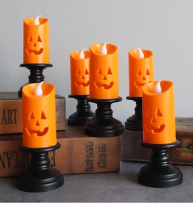 Macro detail of Halloween pumpkin LED candles with vintage bases on decorative books