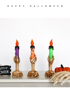 Detailed view of skeletal hand LED candles in purple, orange, and green colors