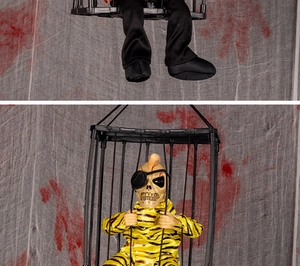 Detail of hanging Halloween prisoner ghost in cage with glowing eyes and striped outfit
