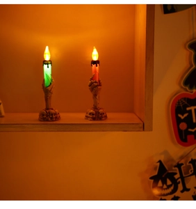 Detailed view of Halloween skeleton hand LED candle lights in green and red festive glow
