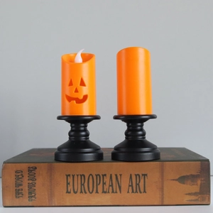 Halloween pumpkin LED candles set with black vintage base on books for festive decor