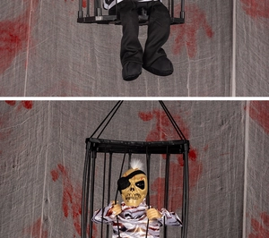 Close-up of a Halloween hanging skeleton prisoner in a cage with striped clothes