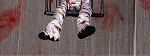 Detail of Halloween prisoner ghost toy featuring tiger print fabric and jagged black hem