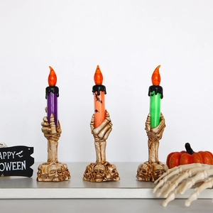 Three LED Halloween skeleton hand candles in purple, orange, and green with bat patterns