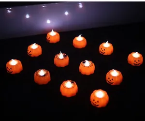 Macro shot of orange LED pumpkin lights featuring spooky face and spider web patterns