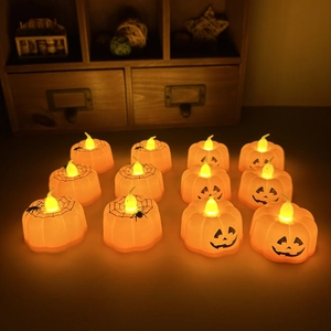 Set of 12 Halloween pumpkin LED tea lights with spooky face and spider web patterns
