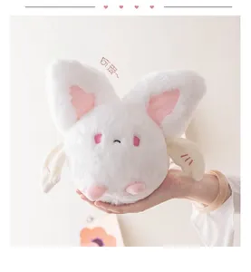 Close-up of a round white bat plush toy with pink ears held in hand for size display