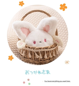 Close-up of cute white plush rabbit with pink wings in a cozy woven basket