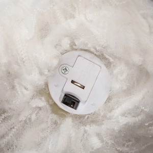 Detail of the white plush Halloween spider prop showing battery compartment and on-off switch