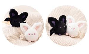 Close-up of cute plush bat toys with big ears and embroidered details on knit blanket