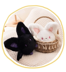 Close-up of cute black and white plush bats with soft fur and embroidered details
