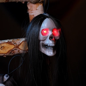 Scary Halloween skull head with long black hair and glowing red LED eyes on wooden beam