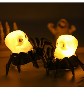 Detail of Halloween spider skeleton LED candles with warm yellow glowing light effects